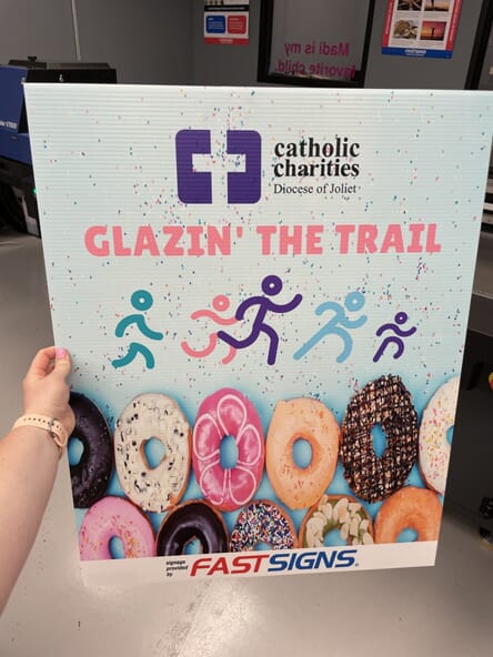 An image of a Catholic Charities Glazin' the Trail signage.